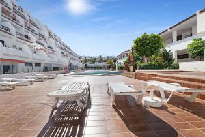 a courtyard with white benches in a building at Ocean Park 311 in Adeje
