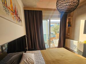 a bedroom with a bed and a large window at 74SUITE Sibenik - Self check in - Garage in Šibenik