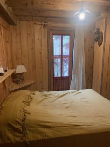 a bedroom with a large bed with a window at Chalet Saint-Roch in Val Cenis