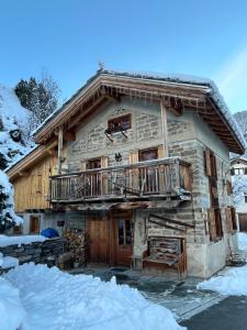 a log cabin in the snow with a balcony at Chalet Saint-Roch in Val Cenis
