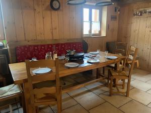 a wooden table with chairs and plates on it at Chalet Saint-Roch in Val Cenis
