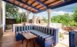 a patio with a blue couch and a wooden table at Casa can Pep Martí in Sant Francesc Xavier
