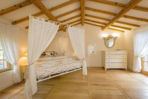 a bedroom with a canopy bed and a dresser at Villa Cava Alta in Riparbella +37 photos