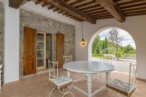 a dining room with a table and chairs on a patio at Villa Cava Alta in Riparbella