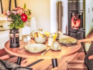 a table with plates of food and a fireplace at Chalet Boutique Tiny House by Interhome in Rothenthurm