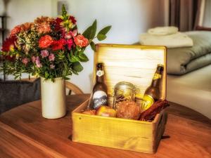 a wooden crate with two bottles of beer and a vase with flowers at Chalet Boutique Tiny House by Interhome in Rothenthurm