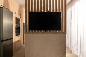 a living room with a flat screen tv on a wall at Cossoro Cave Villa in Vasilikos