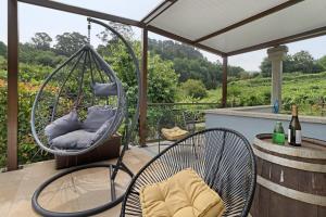 a porch with two chairs and a swing at Quinta Da Cevidade in Melgaço