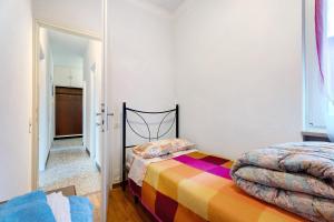 a bedroom with a bed with a colorful blanket at Casa Elsa in Cannobio