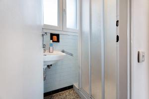 a white bathroom with a sink and a window at Casa Elsa in Cannobio