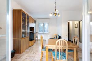 a dining room and kitchen with a wooden table and chairs at Casa Elsa in Cannobio +21 photos