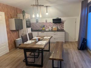 a kitchen with a wooden table and a dining room at Plätzchen am Krebsberg in Simmerath