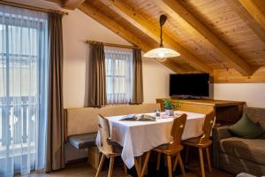 a dining room with a table and a couch at Feldererhof Gsies Apt Almenblick in Valle Di Casies