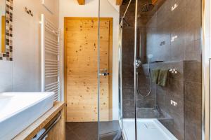 a bathroom with a shower and a sink and a tub at Feldererhof Gsies Apt Almenblick in Valle Di Casies +28 photos