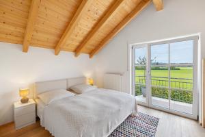 a bedroom with a bed and a large window at Appartement Monte Fiori in Anzing
