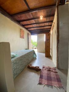a bedroom with a bed and a dog laying on the floor at Tatajuba guest house Casa Pascual in Tatajuba