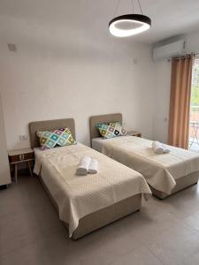 two beds sitting next to each other in a room at Apolana Apartments in Negotino