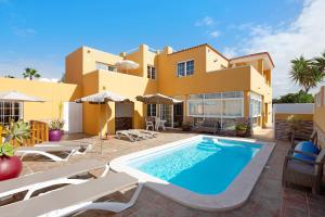 a villa with a swimming pool in front of a house at Casa Paco 3 in Costa Calma
