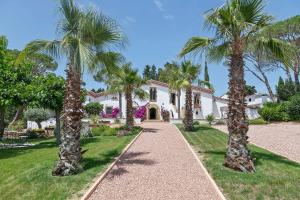 a house with palm trees in front of it at Masia Luxmarspa in Tordera