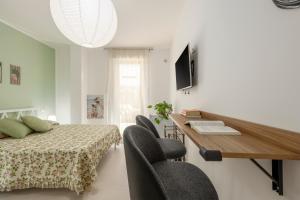 ein Schlafzimmer mit Bett, Schreibtisch und Stühlen in der Unterkunft Lovi Room in Capaci