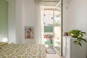 ein Schlafzimmer mit einem Bett und einer Glasschiebetür in der Unterkunft Lovi Room in Capaci