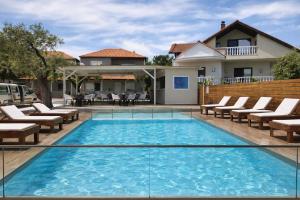a swimming pool with chairs and a house at Studios River - Potos Escape with Pool and Views in Potos