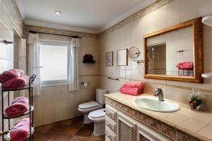 a bathroom with a sink and a toilet and a mirror at Villa Amorós in Cala Ratjada +20 photos