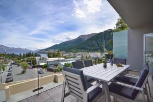 a table and chairs on a balcony with a view at Villa Two at Vailmont Queenstown in Queenstown