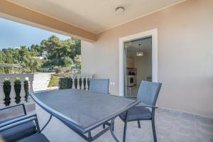 a dining room with a table and chairs on a balcony at Villa sea view 2 in Athani