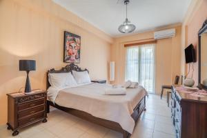 a bedroom with a bed with a dresser and a television at Villa sea view 2 in Athani