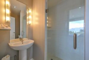 a white bathroom with a sink and a shower at Villa Two at Vailmont Queenstown in Queenstown