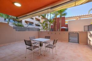 a patio with a table and chairs at Bugalú Playa Paraíso in Adeje