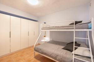 a bedroom with a bunk bed and white cabinets at Bugalú Playa Paraíso in Adeje +17 photos