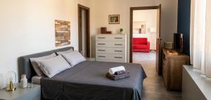 a bedroom with a bed and a dresser and a red chair at a casa di ASIA in Dalmine
