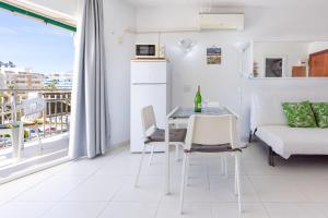 a white living room with a table and a couch at Sunny Seaside Studio in Benalmadena Costa