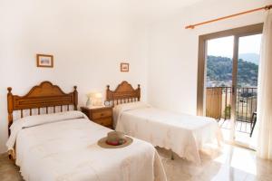 a bedroom with two beds and a balcony at S'ancora in Port de Soller