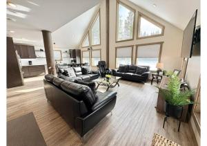 a living room with black leather couches at Sunny Peaks in Valemount
