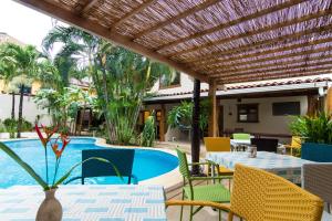 a patio with tables and chairs and a swimming pool at Ten North Tamarindo Beach Hotel in Tamarindo