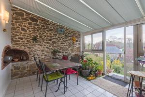 a dining room with a table and a stone wall at O’bord Du Gave in Saucède