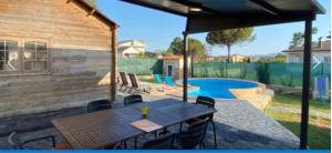 a patio with a table and chairs and a pool at Can dennis in Sils