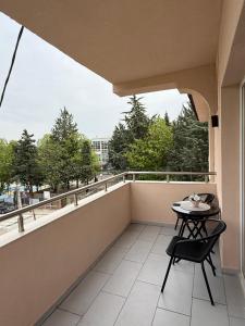 a balcony with a table and chair on a balcony at Apolana Apartments in Negotino