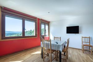 a dining room with a table and chairs and a tv at Casa Do Sil in Monforte de Lemos