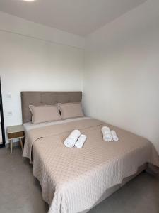 a white bed with two white towels on it at Apolana Apartments in Negotino +7 photos