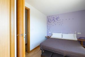 a bedroom with a bed with a purple wall at Casa Do Sil in Monforte de Lemos +21 photos