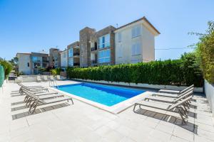 a row of lounge chairs next to a swimming pool at La Plaza in Port de Pollensa