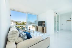 a living room with a couch and a large window at La Plaza in Port de Pollensa