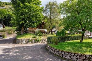 a house with a stone wall next to a road at Casa Belfort per 9 persone in Spormaggiore