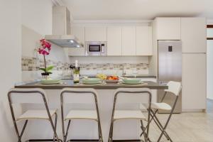 a kitchen with a table with chairs and a refrigerator at Apartamento Rolycar 102 in Icod de los Vinos