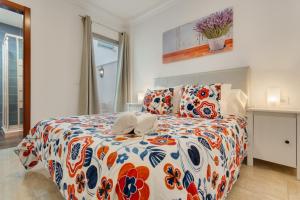 a bedroom with a bed with a colorful comforter at Apartamento Rolycar 102 in Icod de los Vinos