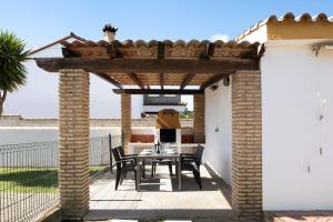 a patio with a table and chairs under a pergola at Casa García in Cádiz
